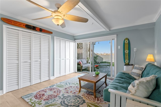 living room with ceiling fan, beam ceiling, wood finished floors, and ornamental molding