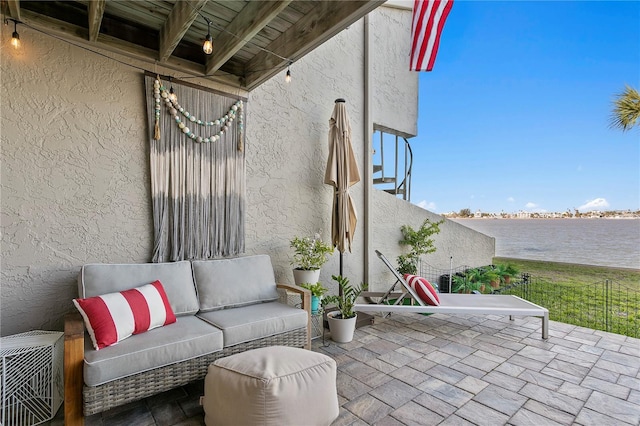 view of patio with a water view and outdoor lounge area