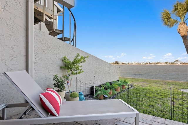 view of patio / terrace with a water view and a balcony