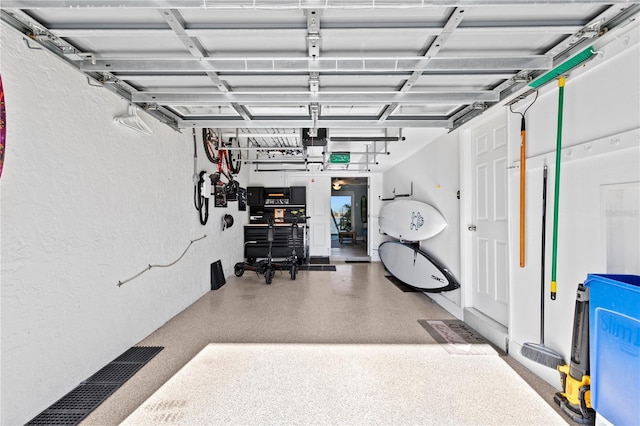 garage featuring a garage door opener and a textured wall