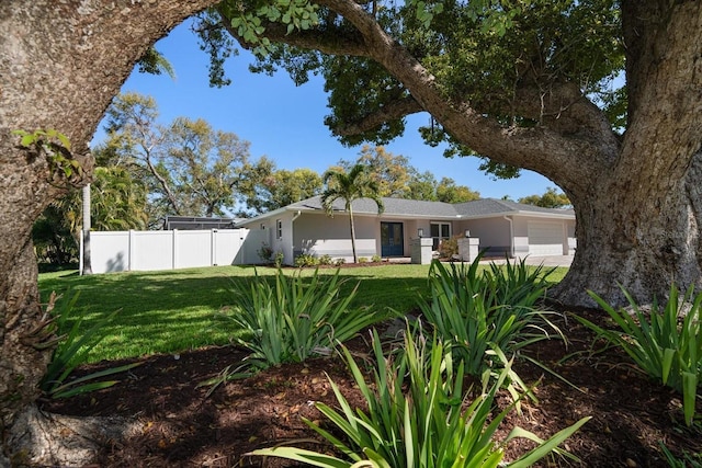 view of front of property with a front lawn, fence, a garage, and stucco siding