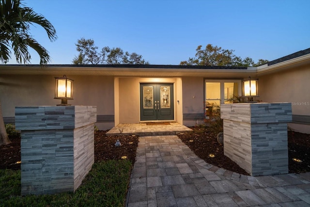 doorway to property featuring french doors and stucco siding