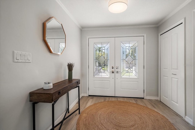 foyer entrance with light wood finished floors, french doors, crown molding, and baseboards