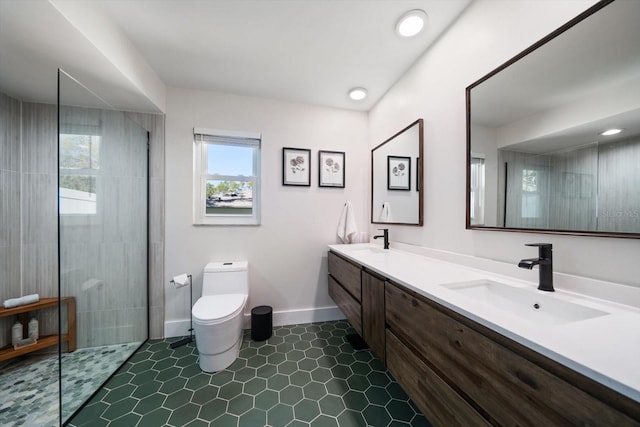 bathroom featuring toilet, a walk in shower, a sink, double vanity, and baseboards