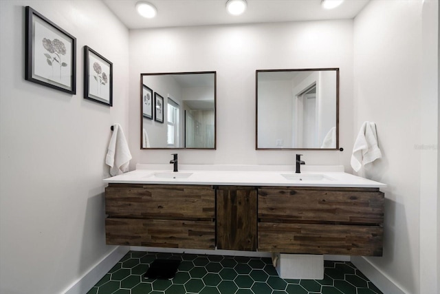 bathroom with a sink, baseboards, and double vanity