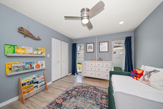 bedroom featuring a ceiling fan, wood finished floors, baseboards, and a closet