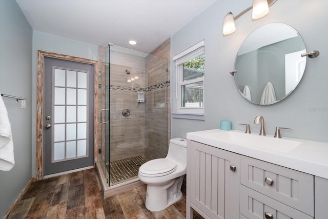 full bathroom with vanity, wood finished floors, recessed lighting, a shower stall, and toilet