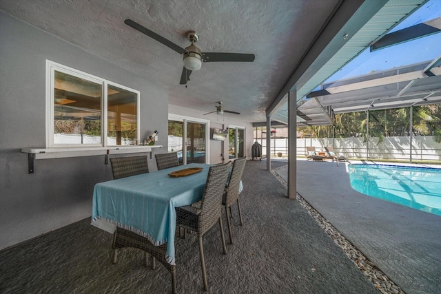 view of patio featuring a fenced in pool, fence, a lanai, outdoor dining area, and a ceiling fan