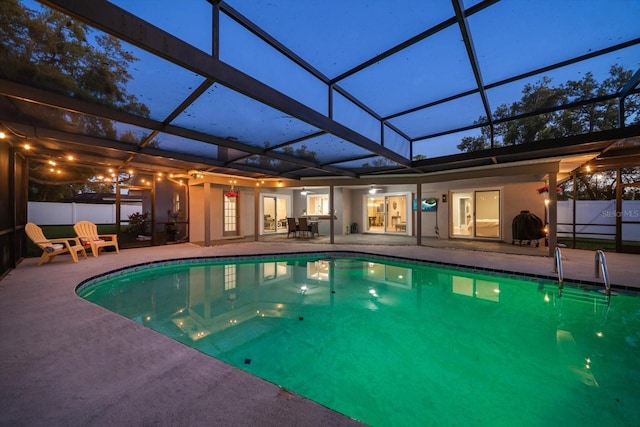 view of swimming pool with glass enclosure, fence, a patio area, and a fenced in pool