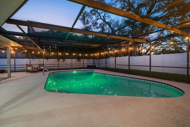 view of pool with glass enclosure, a patio, and a fenced backyard