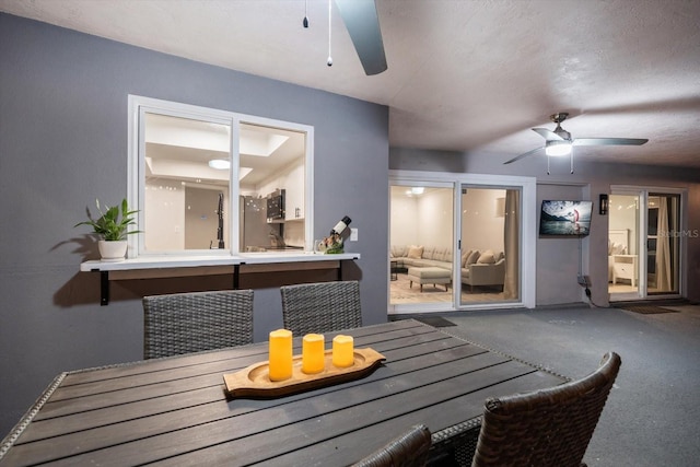 dining space with carpet flooring, a ceiling fan, and a textured ceiling