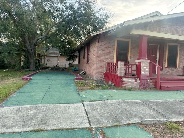 view of property exterior featuring brick siding and covered porch