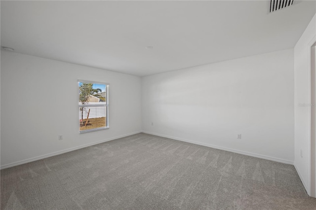 carpeted empty room with visible vents and baseboards