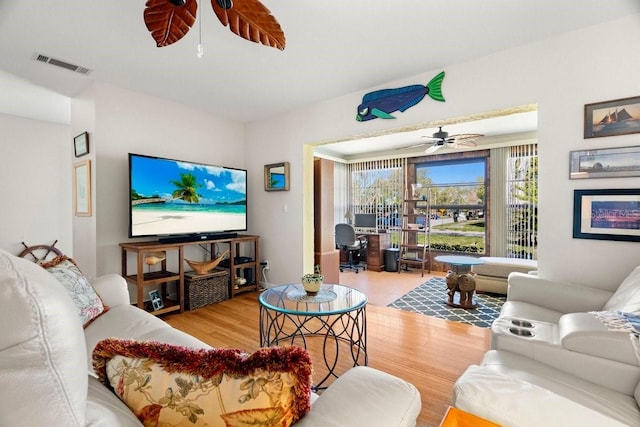 living area featuring visible vents, ceiling fan, and wood finished floors