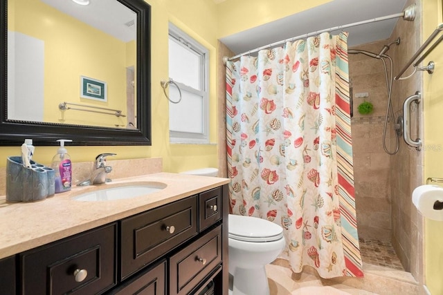 full bathroom featuring tiled shower, toilet, and vanity