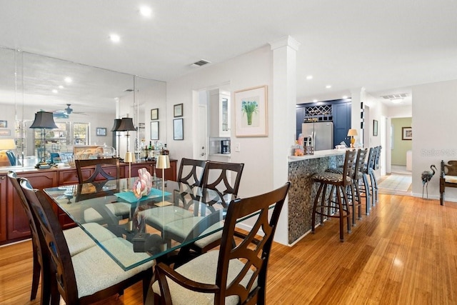 dining area featuring recessed lighting, visible vents, light wood-style flooring, and decorative columns