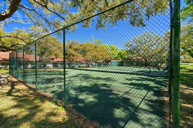 view of tennis court featuring fence