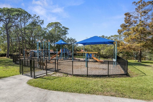 community jungle gym featuring a lawn and fence