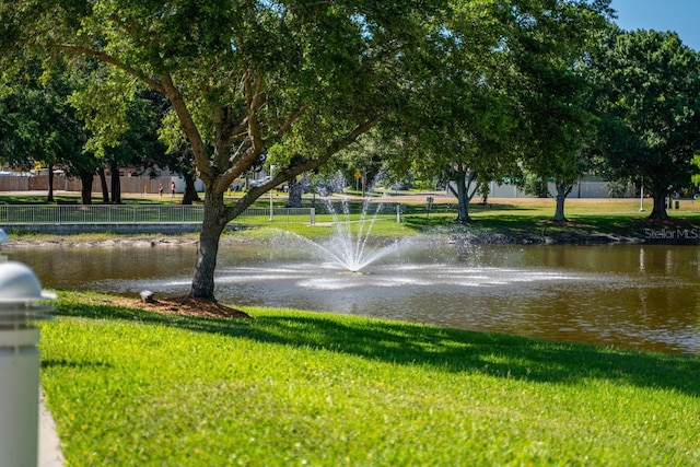 view of community with a water view and a lawn