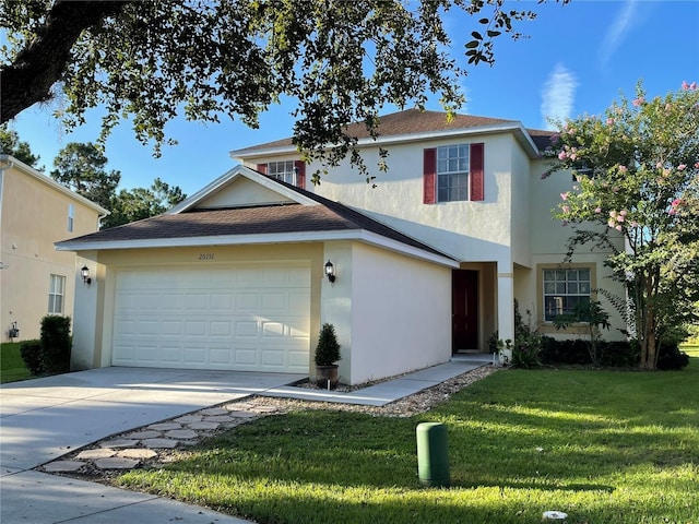 traditional home with stucco siding, driveway, roof with shingles, a front yard, and an attached garage