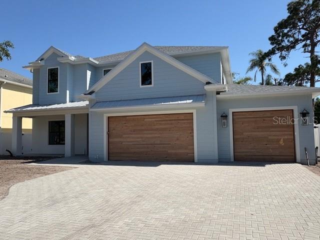view of front of house with a standing seam roof, metal roof, and decorative driveway