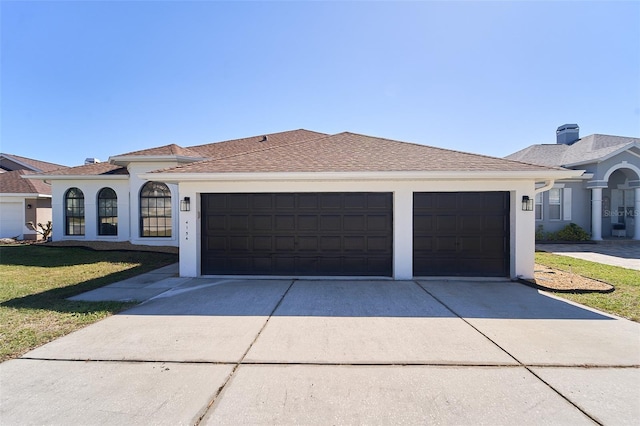 view of front facade with stucco siding, driveway, an attached garage, and a shingled roof