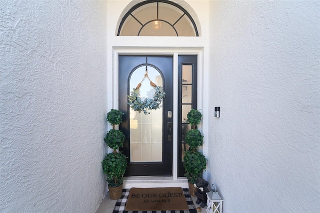 doorway to property featuring stucco siding