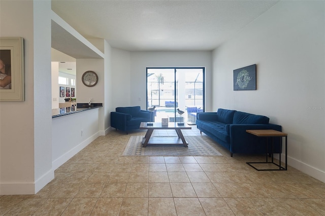 living area featuring baseboards and light tile patterned flooring