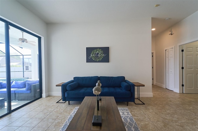 living room featuring light tile patterned flooring, baseboards, and a ceiling fan