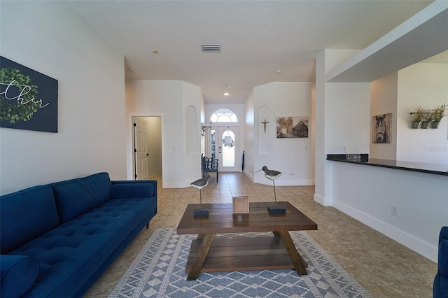 living area with visible vents, baseboards, and tile patterned flooring