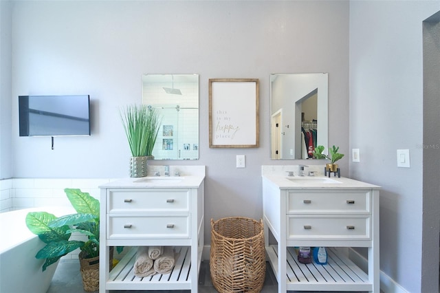 bathroom with a sink, a soaking tub, and two vanities