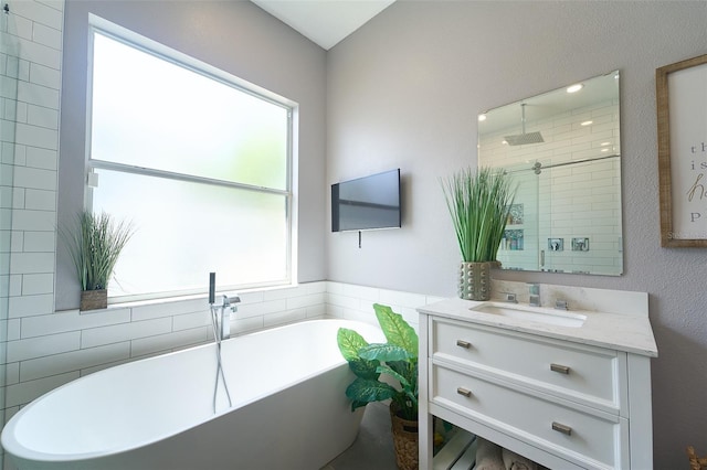 full bath featuring a stall shower, a freestanding bath, and vanity