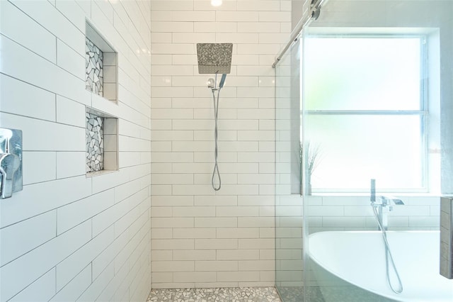 full bathroom featuring a freestanding bath and a tile shower