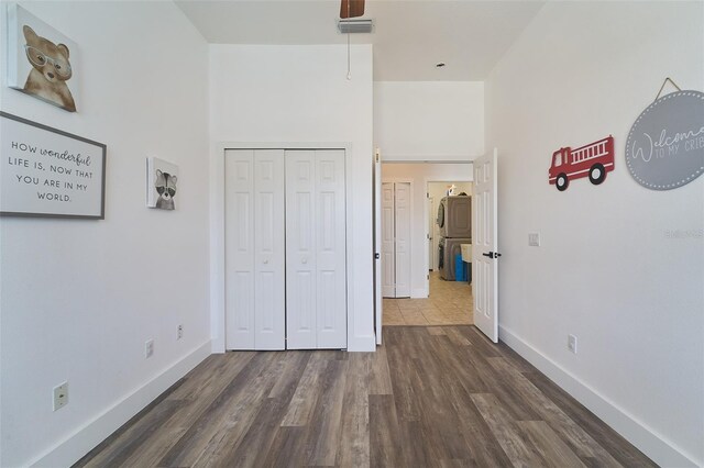 unfurnished bedroom featuring wood finished floors, visible vents, a closet, and baseboards