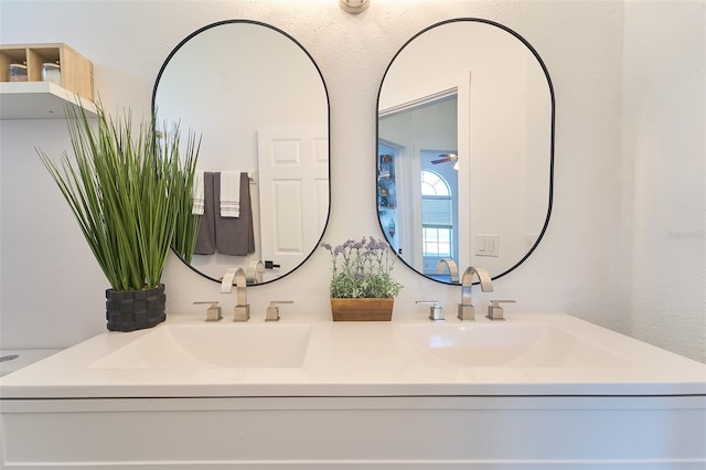 bathroom with double vanity, a ceiling fan, and a sink