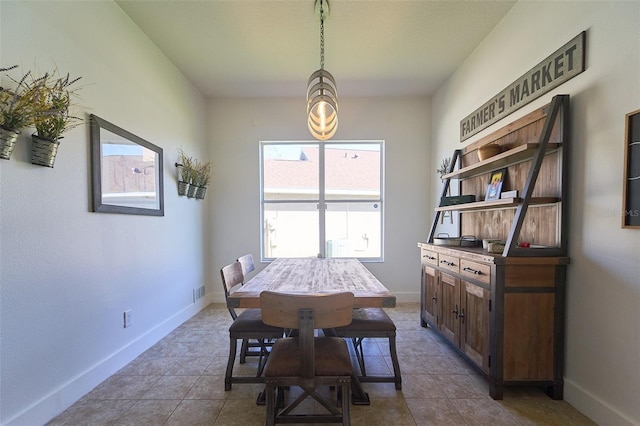 tiled dining space featuring baseboards