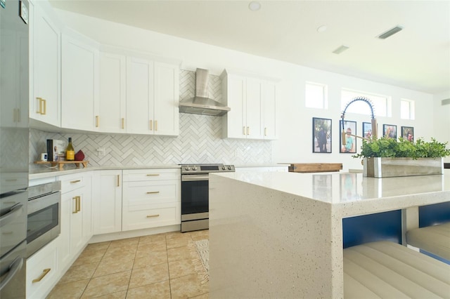 kitchen with a kitchen island, decorative backsplash, stainless steel range with electric stovetop, white cabinets, and wall chimney exhaust hood