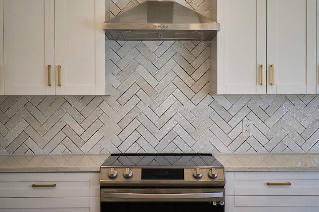 kitchen with decorative backsplash, extractor fan, stainless steel electric stove, and white cabinetry