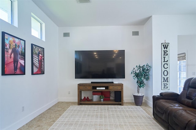 living room featuring tile patterned floors, visible vents, and baseboards