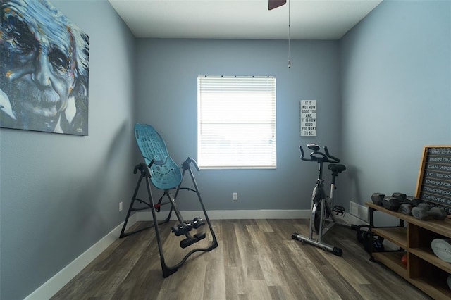 exercise area featuring baseboards and wood finished floors