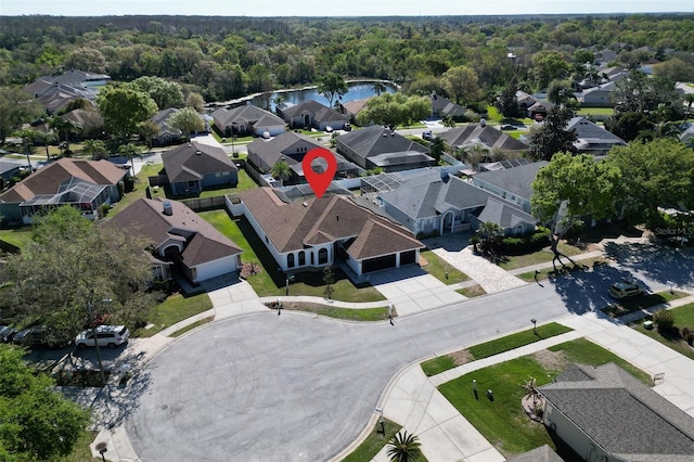 drone / aerial view featuring a residential view, a view of trees, and a water view