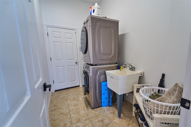 clothes washing area with laundry area, stacked washer / dryer, light tile patterned floors, and a sink