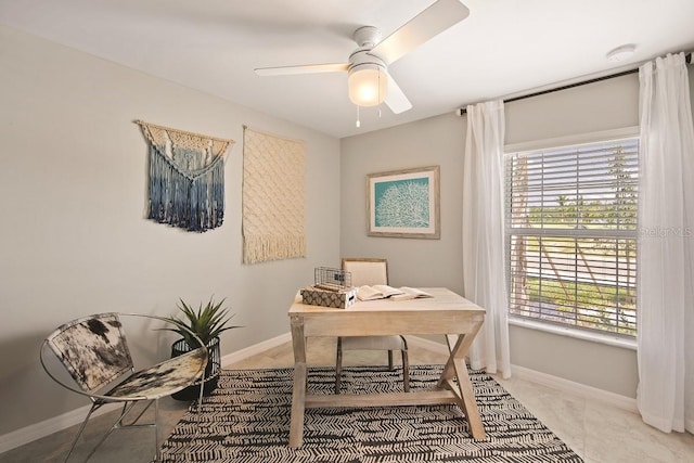 office space with baseboards and a ceiling fan