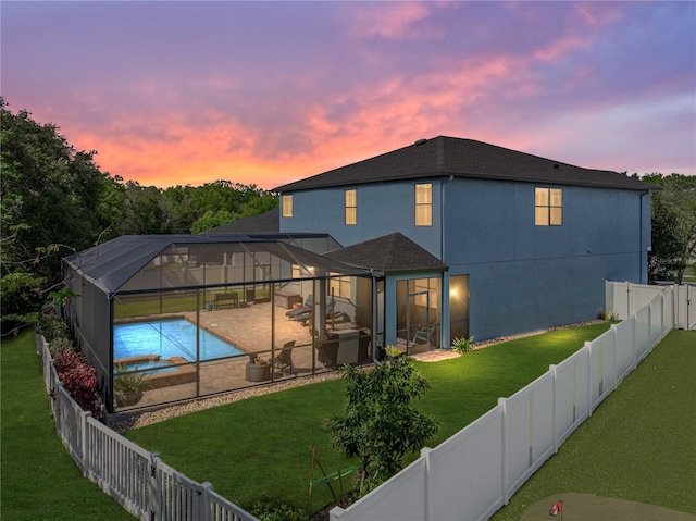 back of house featuring a pool with connected hot tub, a fenced backyard, a yard, a lanai, and a patio area