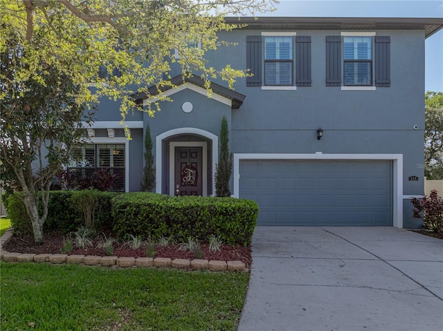 view of front of house with stucco siding, driveway, and a garage