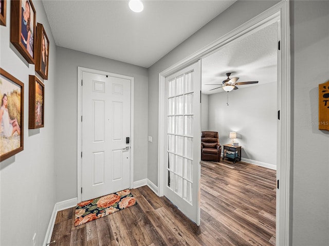 foyer entrance featuring baseboards, dark wood-style floors, and a ceiling fan