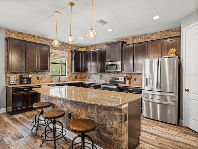 kitchen featuring dark brown cabinetry, visible vents, appliances with stainless steel finishes, and a sink