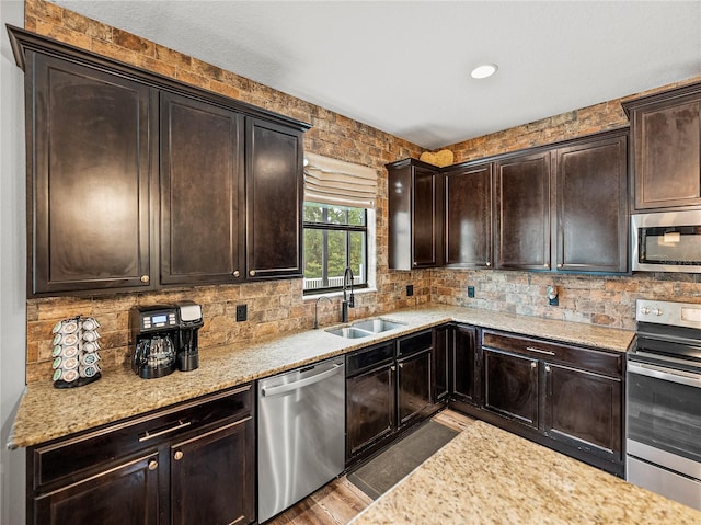 kitchen with a sink, dark brown cabinetry, backsplash, and stainless steel appliances