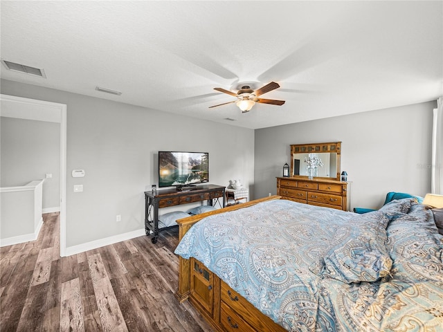 bedroom with visible vents, a ceiling fan, baseboards, and wood finished floors