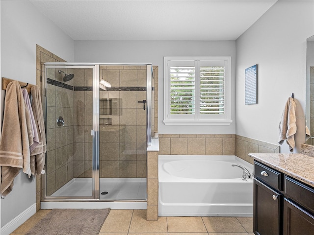 bathroom with a stall shower, a bath, vanity, and tile patterned flooring